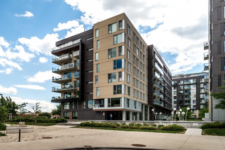 Seven-storey condominium building with balconies and a landscaped courtyard, the type of building covered by the contingency fund study (Bill 16).