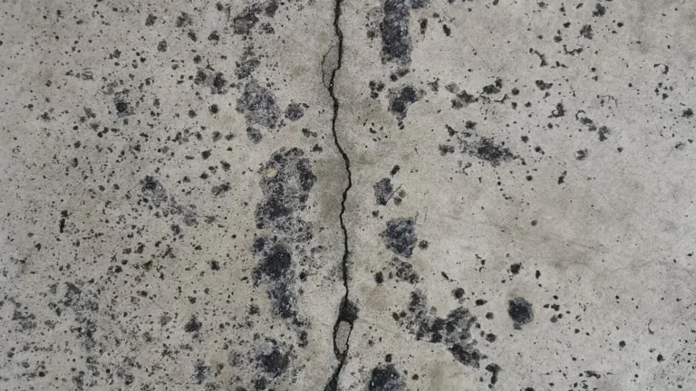 Fissure verticale dans un mur de fondation en béton taché