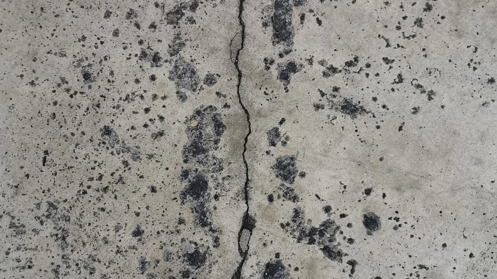 Fissure verticale dans un mur de fondation en béton taché